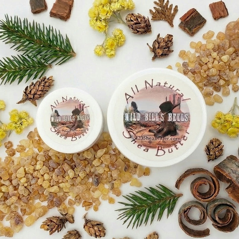 Two containers of 'All Natural Wild Hills' body butter surrounded by natural ingredients on a white background.
