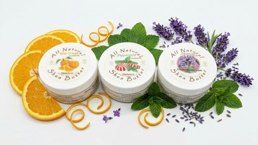 Three jars of All Natural Shea Butter with orange slices, lavender flowers, and green leaves on a white background.
