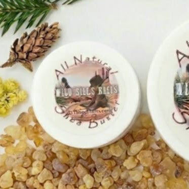 Wild Bill's Heels Shea Butter travel size with cypress leaves, helichrysum flower and frankincense resin around it